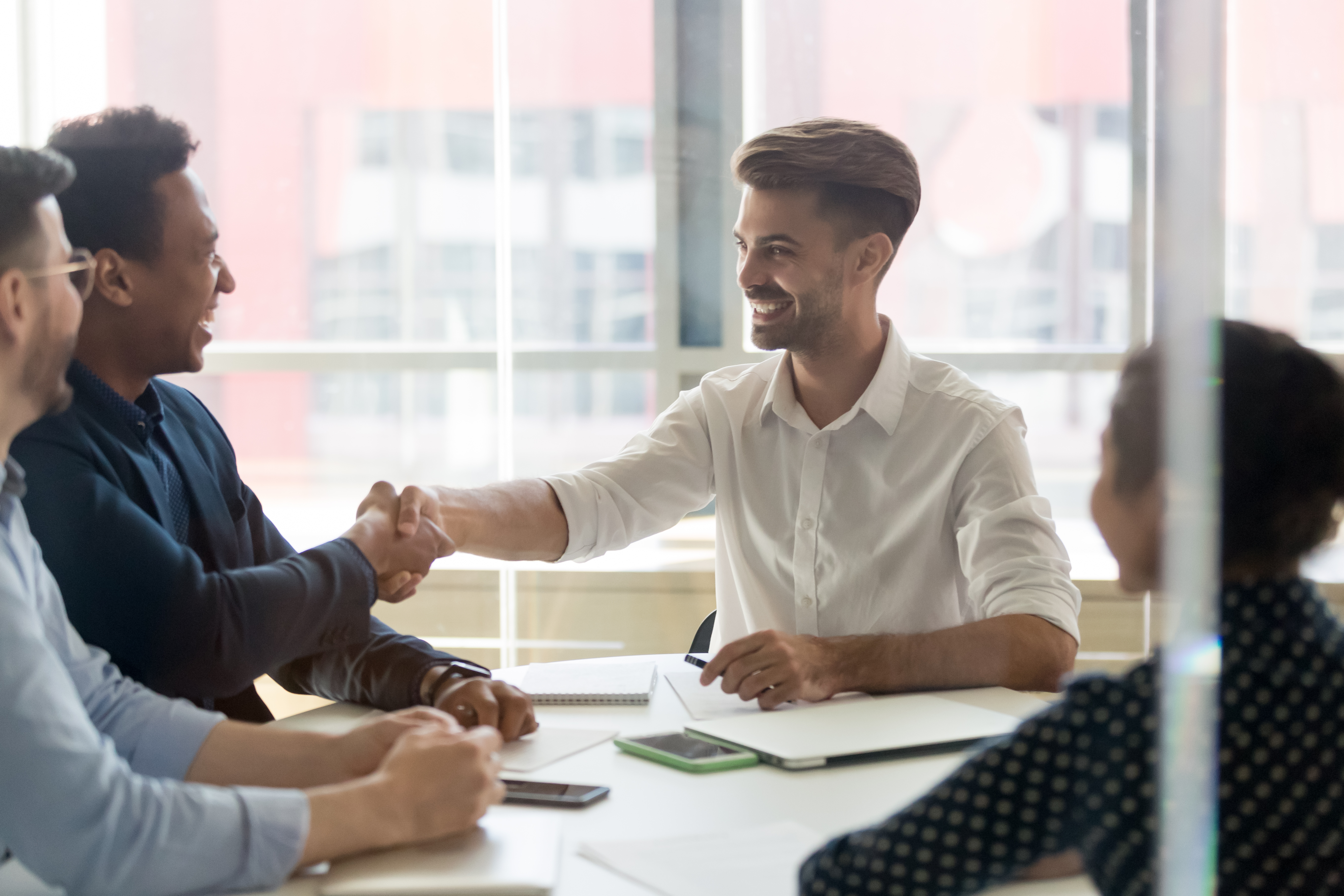 B2B professionals shaking hands in a meeting