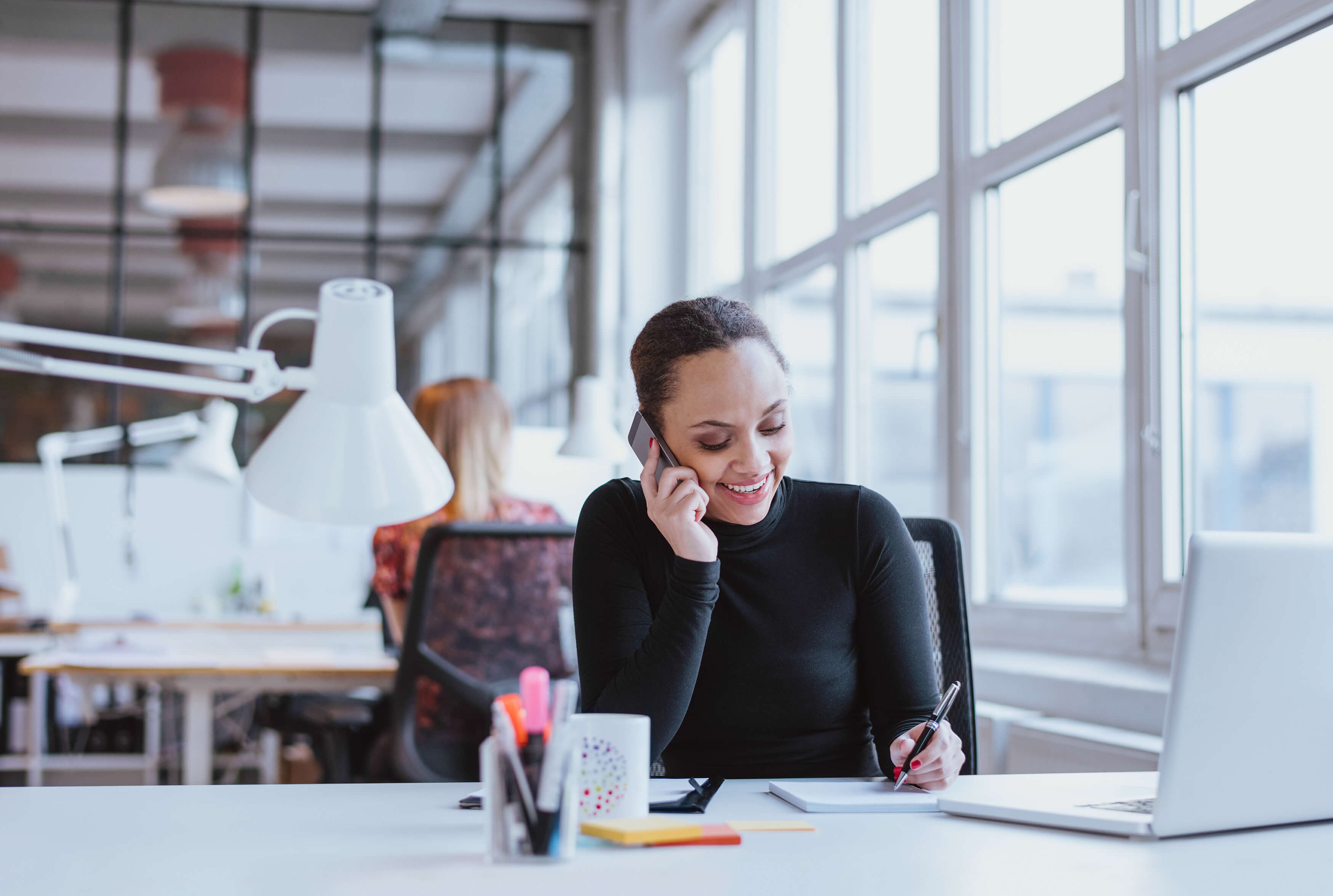 Woman working at desk on the phone