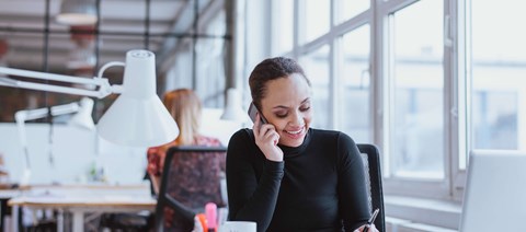 Woman At Desk Working On The Phone
